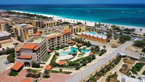 A resort with multiple buildings, a swimming pool, and a beach view. - OUTSTANDING OASIS 4th FLOOR CONDO At EAGLE BEACH (Oranjestad, Aruba)