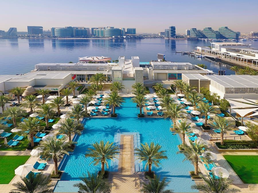 Een buitenzwembad, ligstoelen bij het zwembad