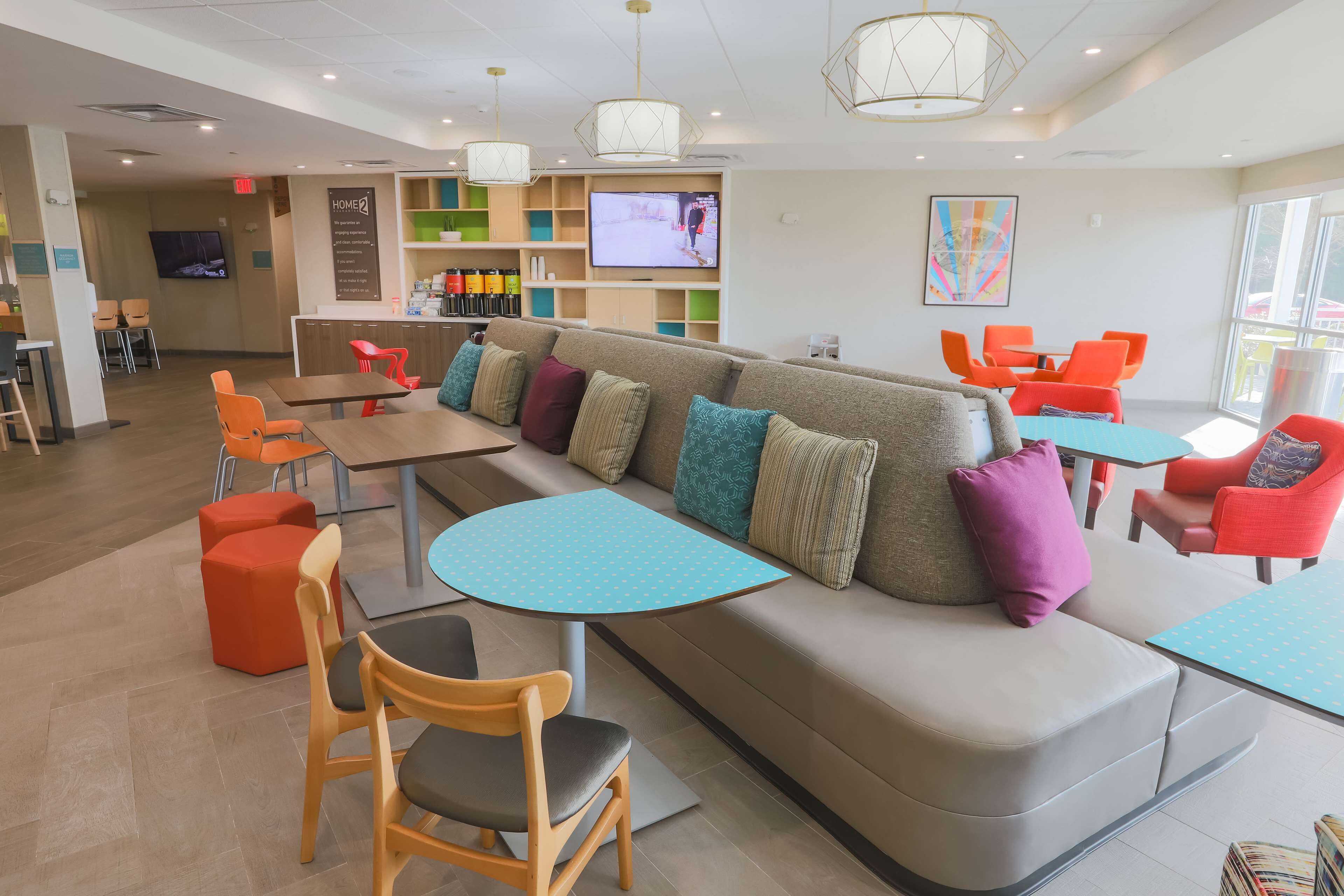 Ein stilvoller Lounge-Bereich mit einer Couch, Sesseln, Tischen, einem Fernseher und einer Bar.