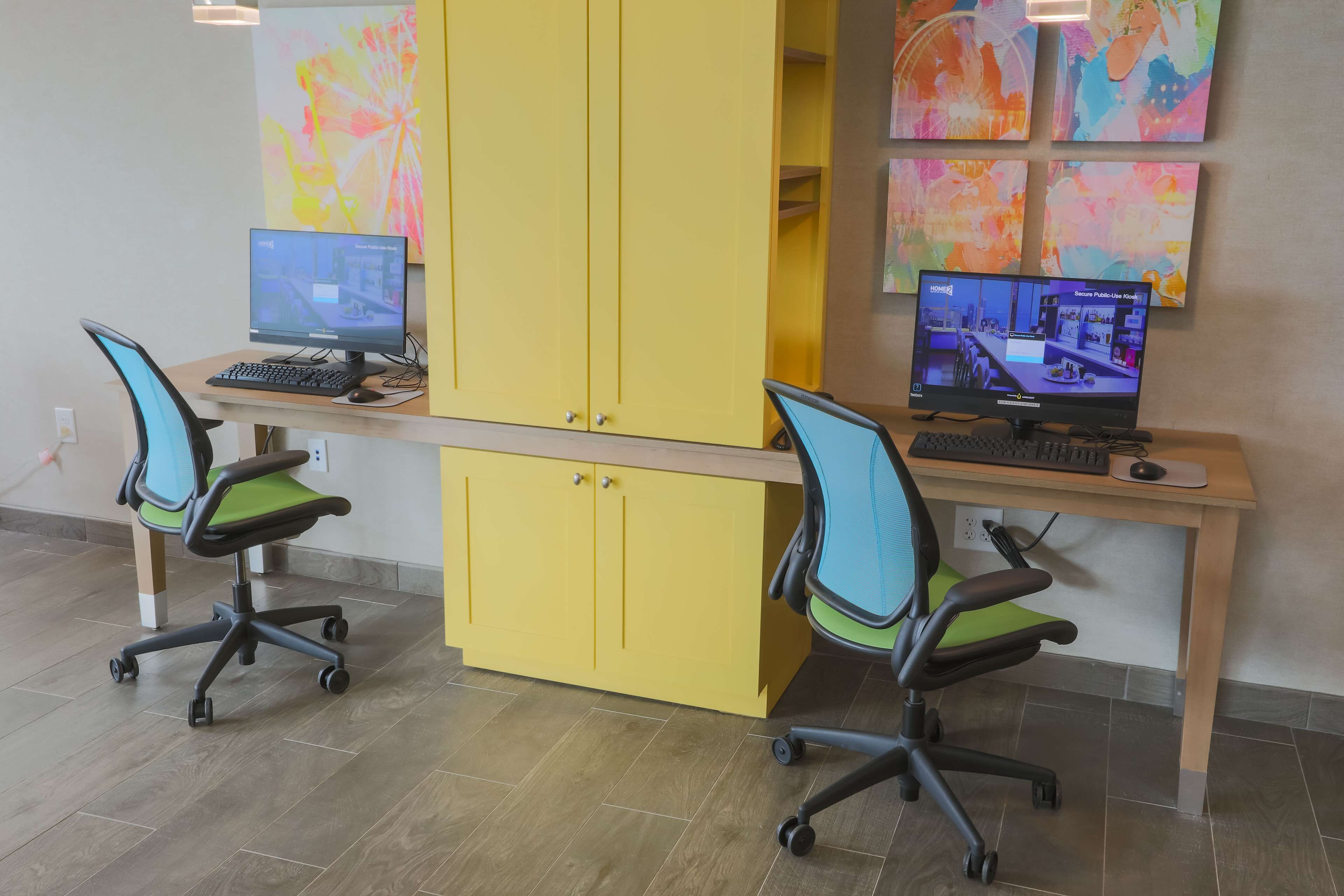 A workspace with two desks, each with a computer and an ergonomic chair.