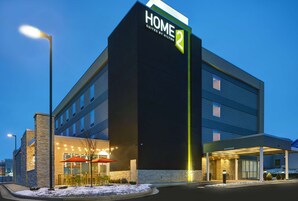 Un moderno edificio de hotel con un letrero llamativo que dice "HOME 2 Suites by Hilton".