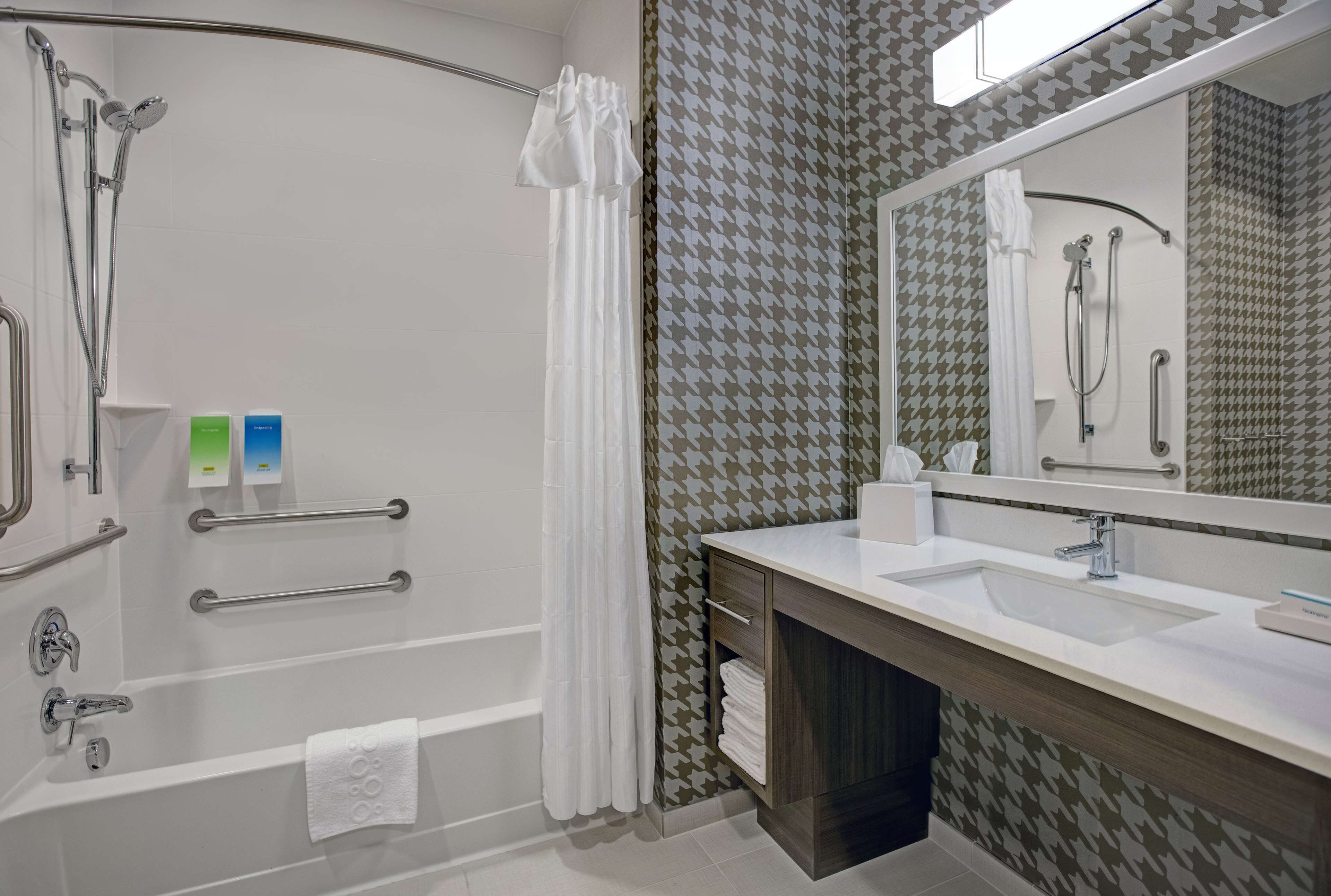 Un baño moderno con bañera, ducha y tocador.