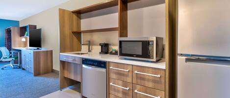 A modern kitchen with a built-in microwave, dishwasher, and refrigerator.