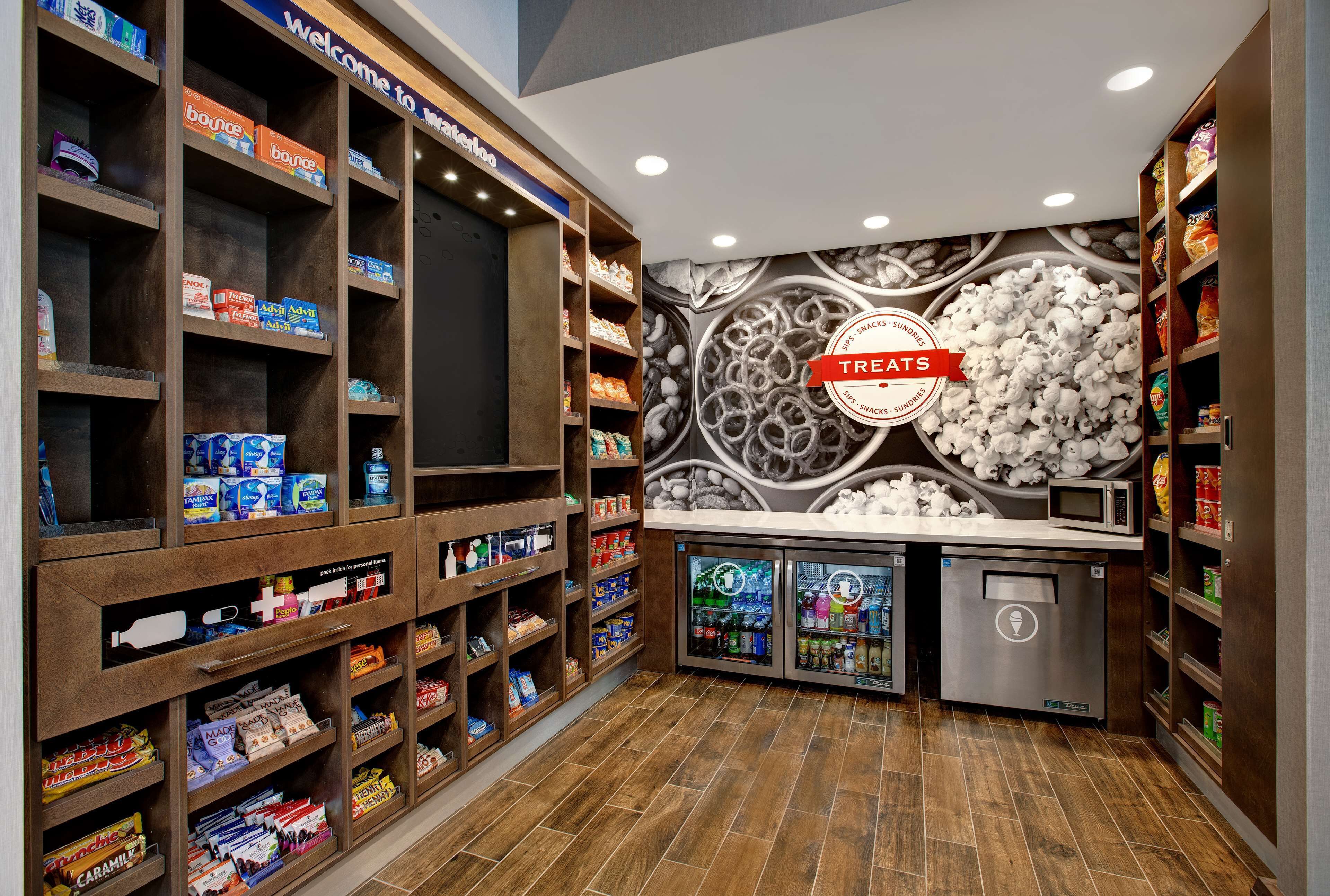 Un bar de aperitivos con estantes llenos de diversas opciones y un refrigerador.
