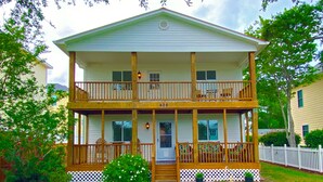 A two-story house with a front porch, a balcony on the upper floor, and a number '602' on the front.