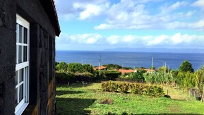 A coastal view with a house and a grassy area in the foreground.