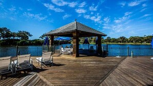 A wooden deck with a gazebo, outdoor seating, and a view of a lake. - PARADISE FOUND! NOW BOOKING FOR 2026! (Naples)