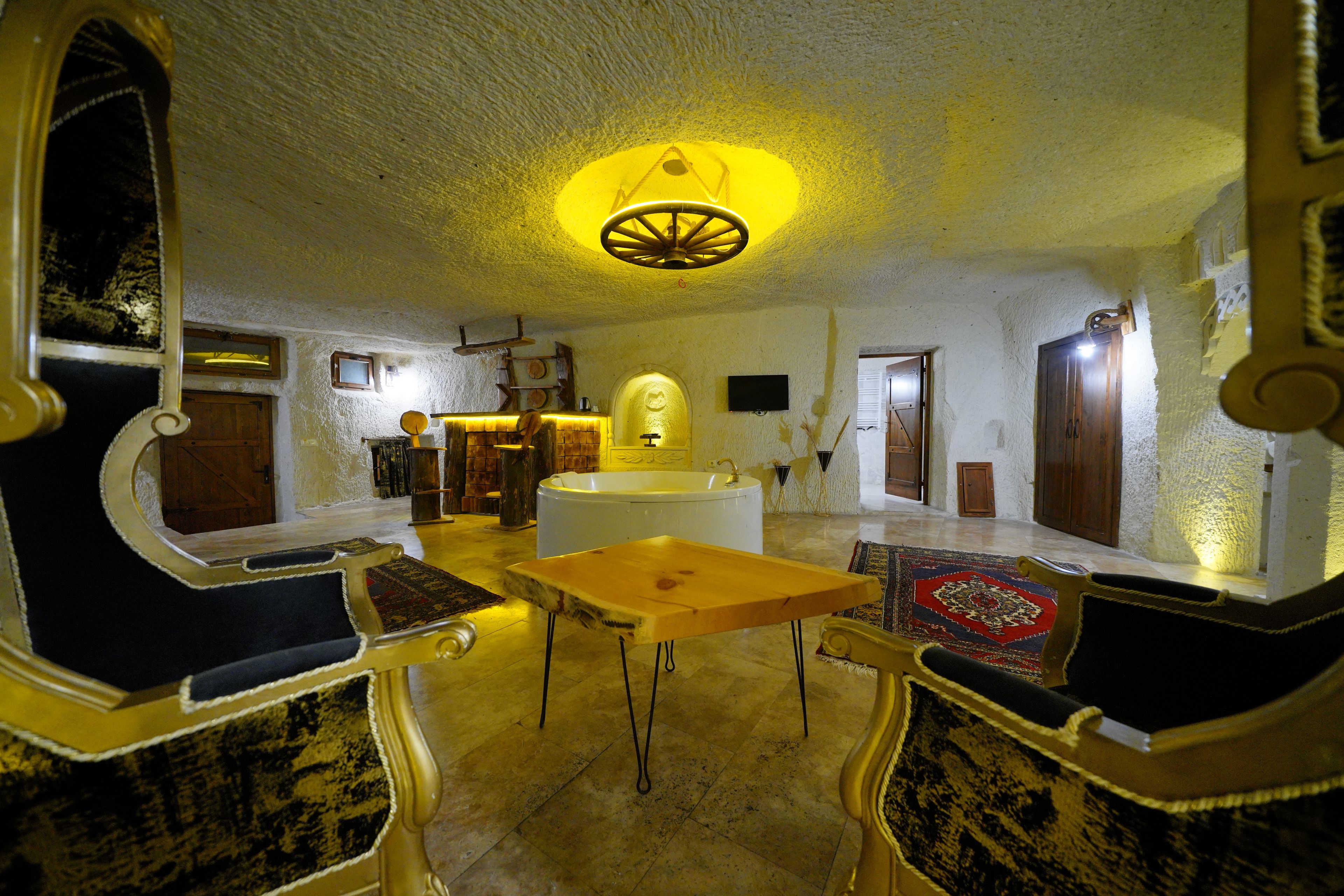 Une pièce dotée d’une grande baignoire, de meubles en bois et d’un luminaire au plafond original.