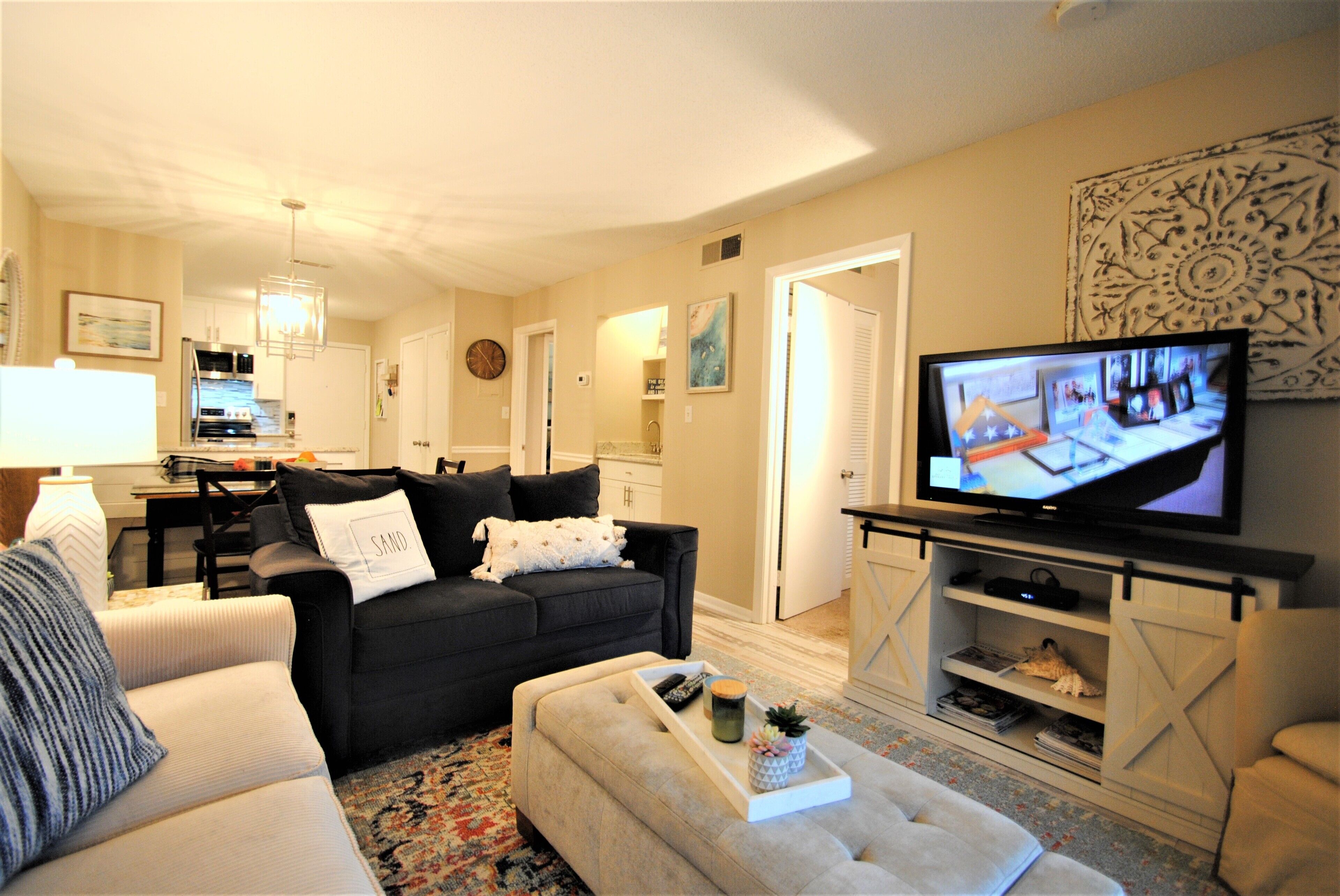 Ein Wohnzimmer mit Fernseher, Sofas und einem Couchtisch.