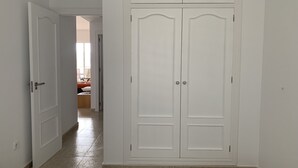 A hallway with a white wardrobe, a door leading to a room, and a tiled floor. - Nice and cozy apartment, private parking and sea views in Cabo de Palos. (Cabo de Palos)