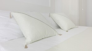 Una cama bien hecha con dos almohadas y una manta.