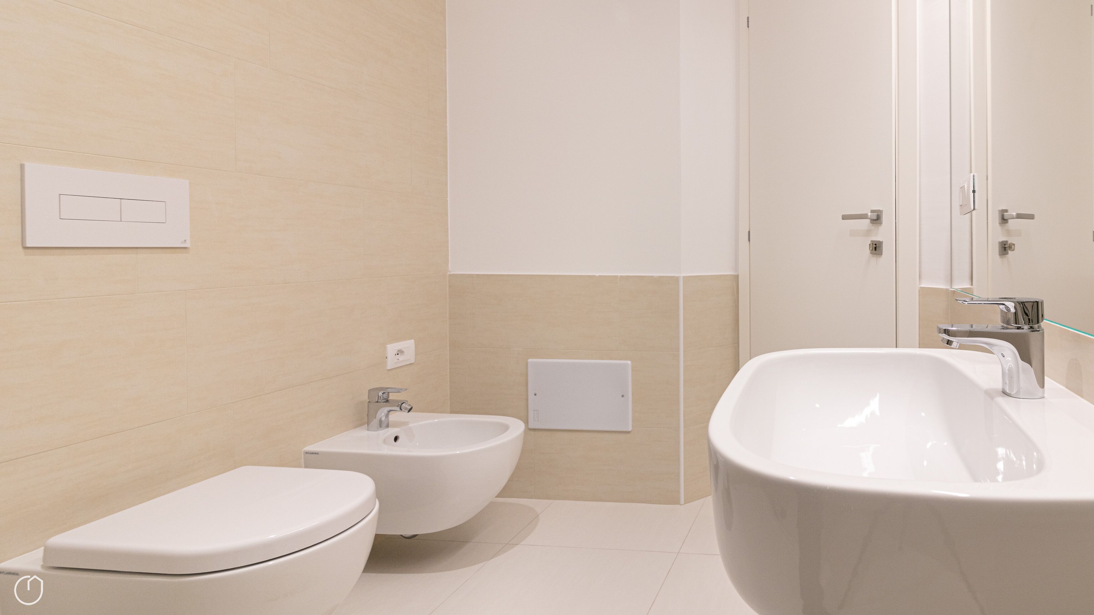 Een moderne badkamer met toilet, bidet en een ruime badkuip.