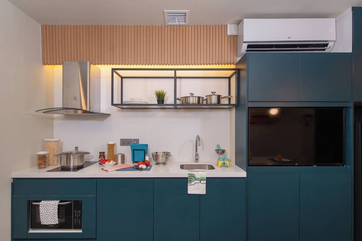 Uma cozinha moderna com forno embutido, micro-ondas e pia.