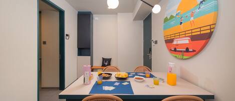 A dining area with a table set for four, including plates, bowls, and drinks.