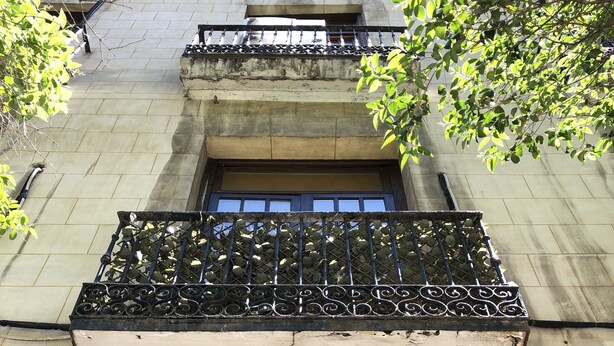 Fachada de edificio con balcón, ventana y puerta.