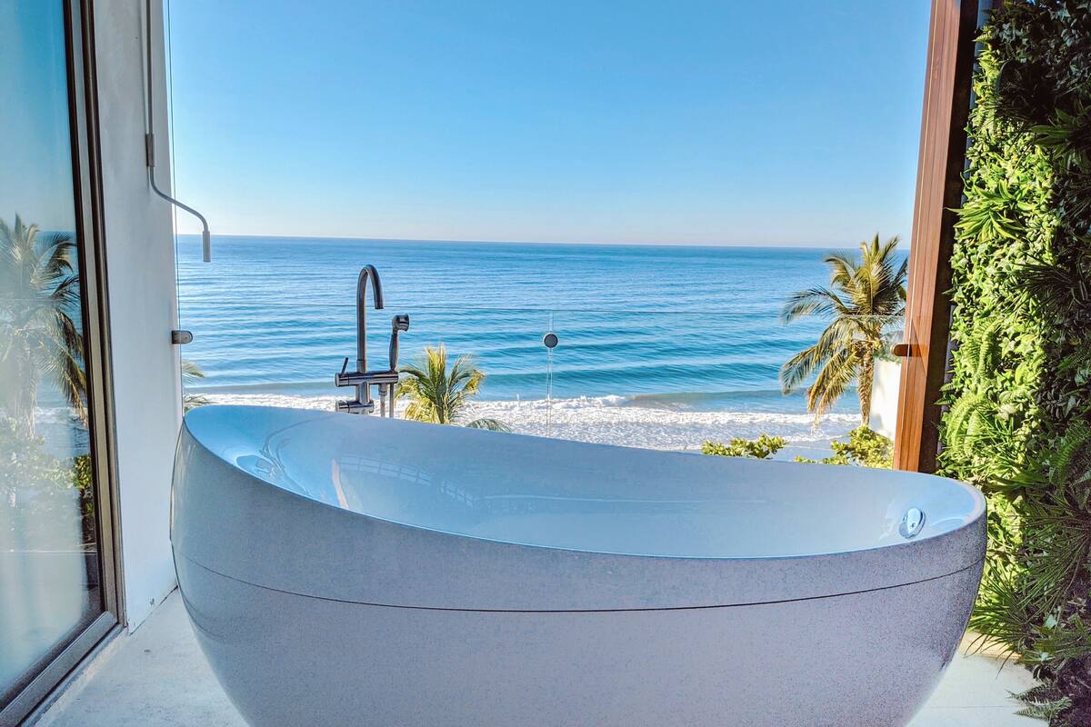 A large freestanding bathtub with a view of the ocean.