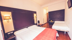 A hotel room with two beds, a desk, a chair, and a small table with a fruit basket. - Hostal Sol Los Angeles (Madrid)