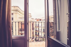 A view from a balcony with a metal railing, overlooking a street with buildings and a clear sky. - Hostal Sol Los Angeles (Madrid)