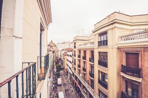 A narrow street between buildings with balconies and a pedestrian walkway. - Hostal Sol Los Angeles (Madrid)