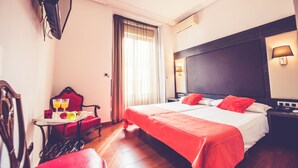 A hotel room with a bed, a chair, a table with breakfast, a TV, and a window with curtains. - Hostal Sol Los Angeles (Madrid)