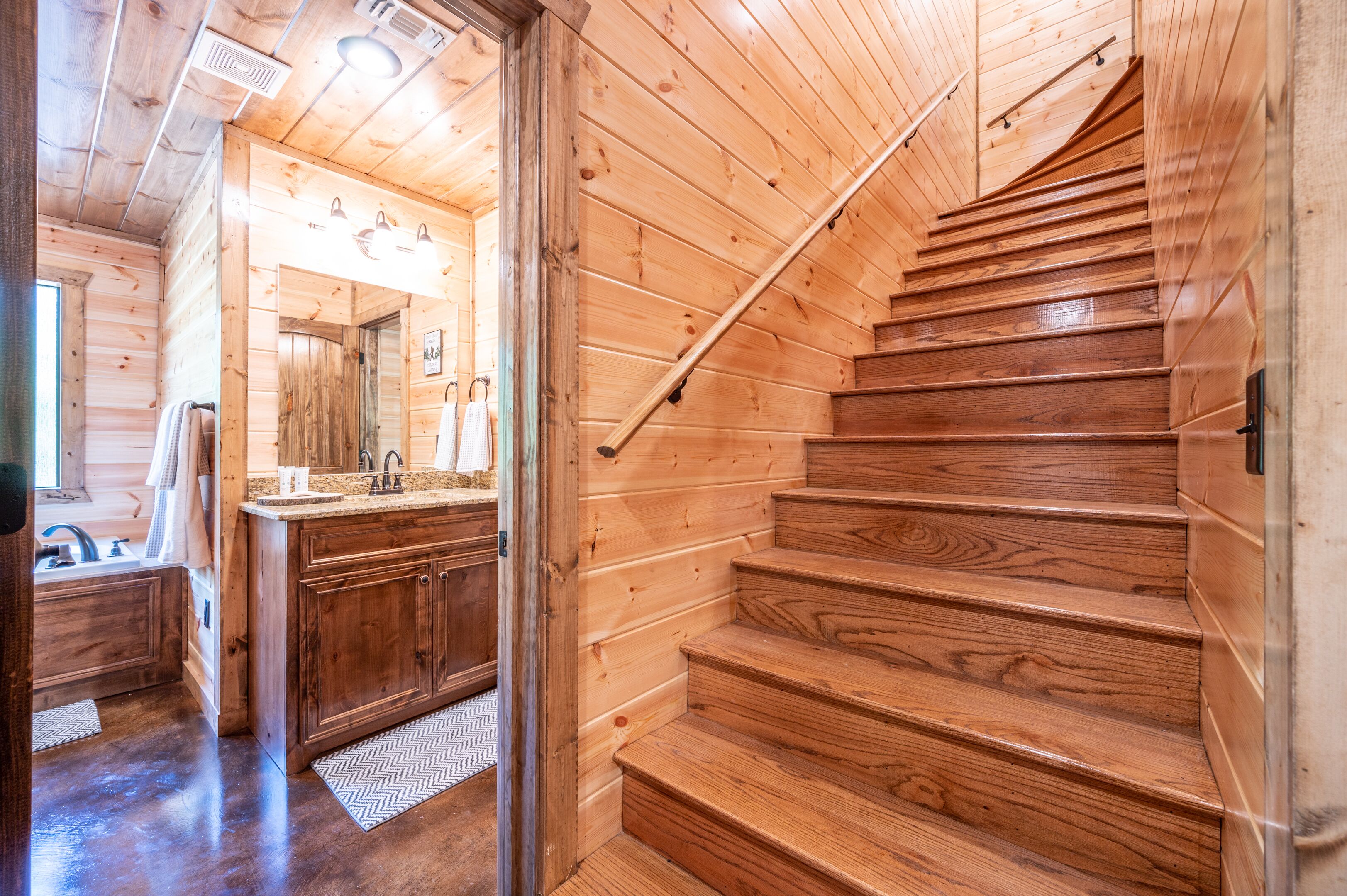 A wooden interior with a staircase leading to a bathroom.