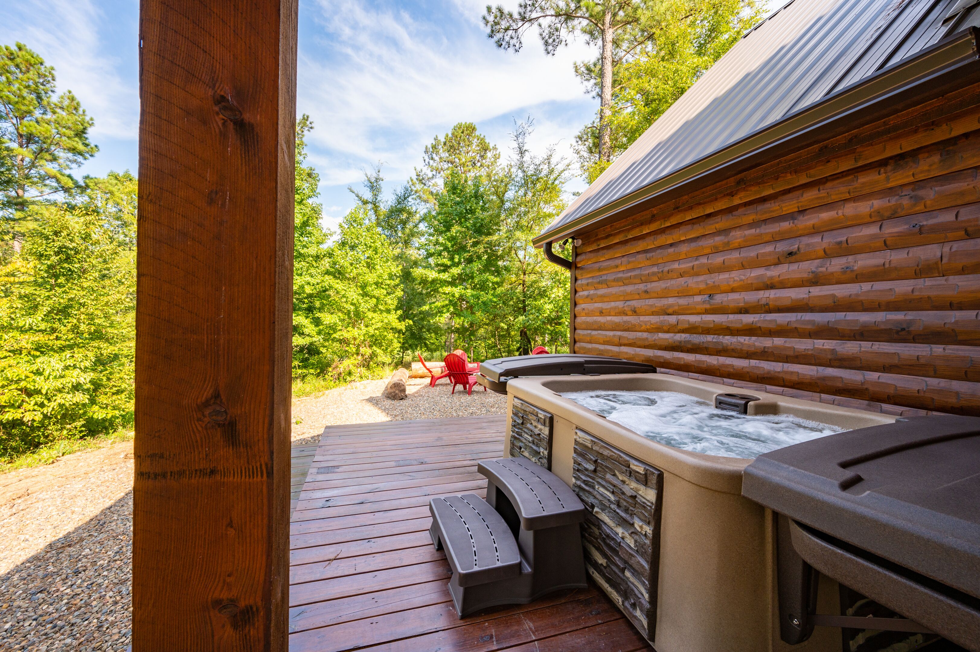 A wooden cabin with a hot tub and outdoor seating.