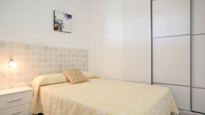 Ein Schlafzimmer mit einem Bett, einem Nachttisch, einer Wandlampe und einem Fenster mit Blick.