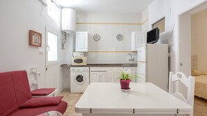 Eine kleine Küche mit Waschmaschine, Mikrowelle und kleinem Fernseher.
