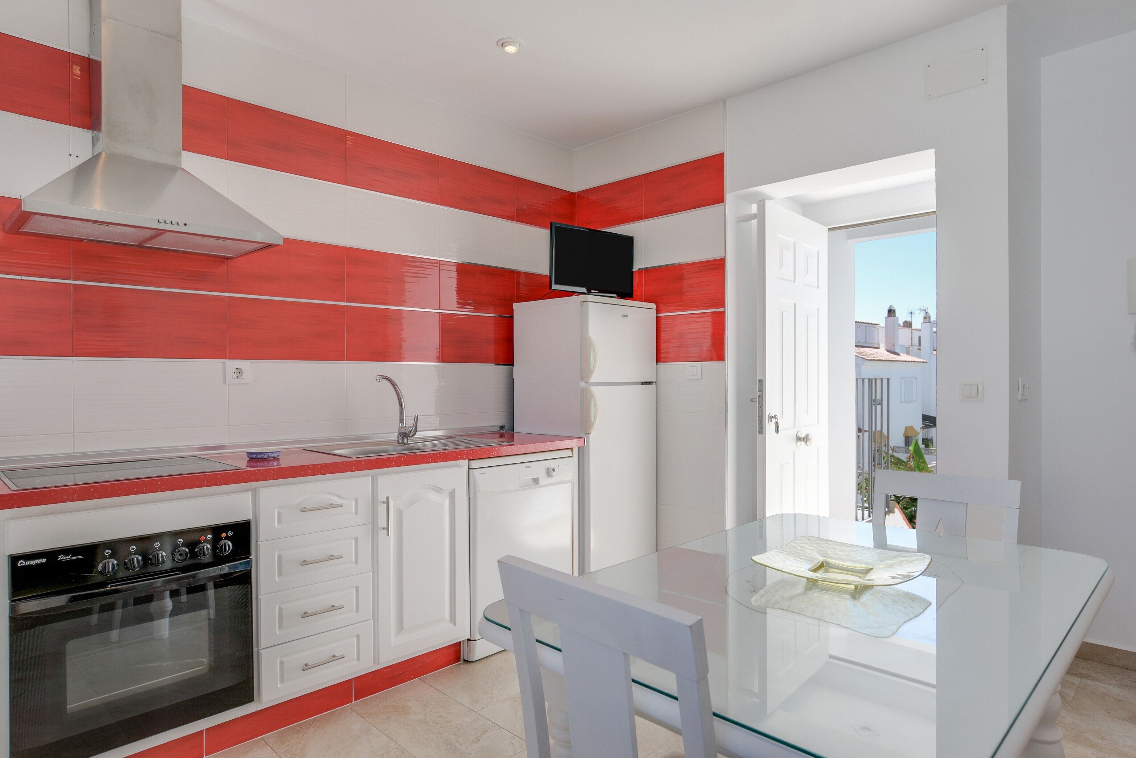 A modern kitchen with a built-in oven, a dishwasher, and a refrigerator.