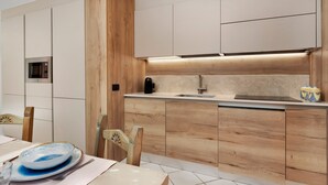 Una cocina moderna con armarios de madera, microondas integrado y cafetera.