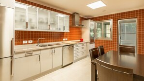 A modern kitchen with white cabinets, a stainless steel refrigerator, and a large island with chairs. - Apartment "Happy Dreamer" with Large Pool, Mountain Views & Wi-Fi (Puerto Rico)