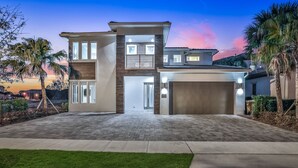 A modern two-story house with a driveway, garage, and well-maintained lawn.