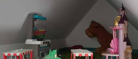Zona de juegos infantiles con trenes de juguete y una estructura de castillo.