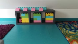 Un depósito de almacenamiento con varios compartimentos, cada uno con bloques de construcción de colores.