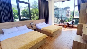Een hotelkamer met twee bedden, een tafeltje, een stoel en een televisie.