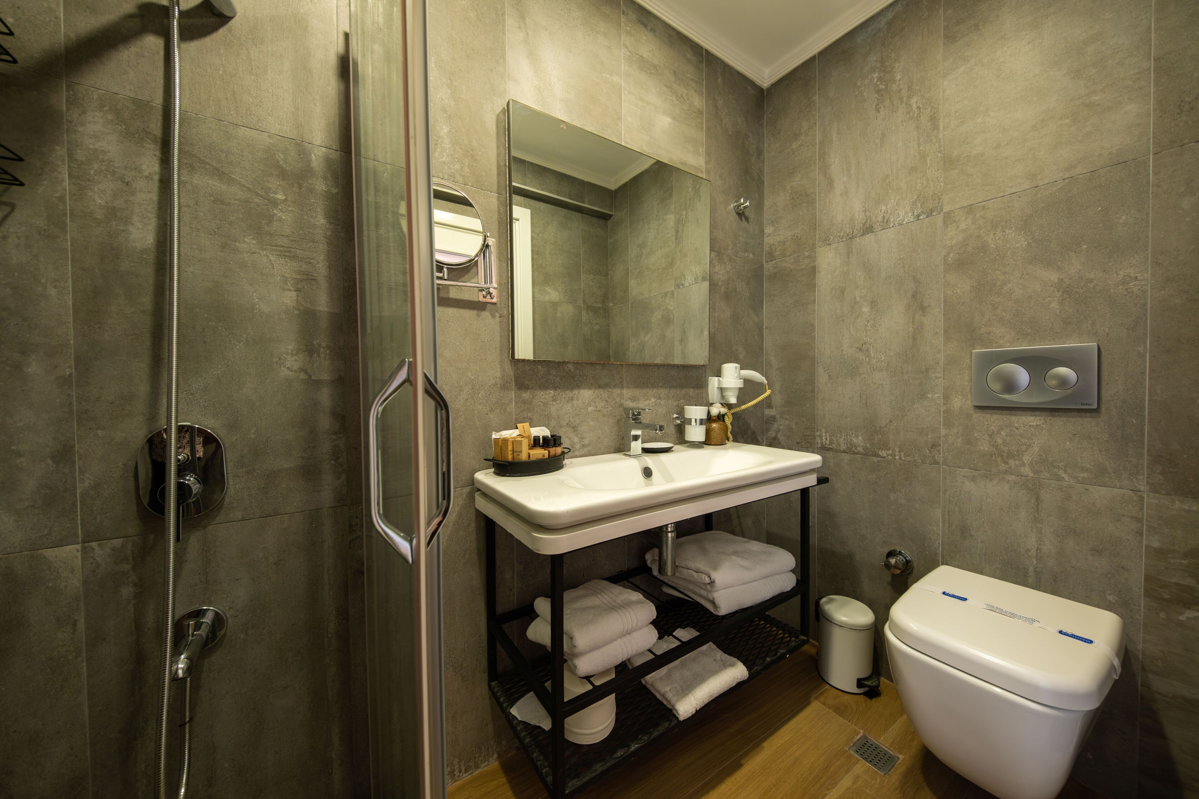 A modern bathroom with a shower, sink, and toilet.