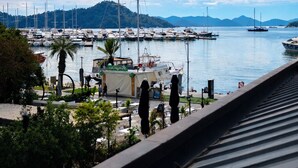 Un port de plaisance avec des bateaux, un ciel dégagé et un paysage vallonné en arrière-plan.