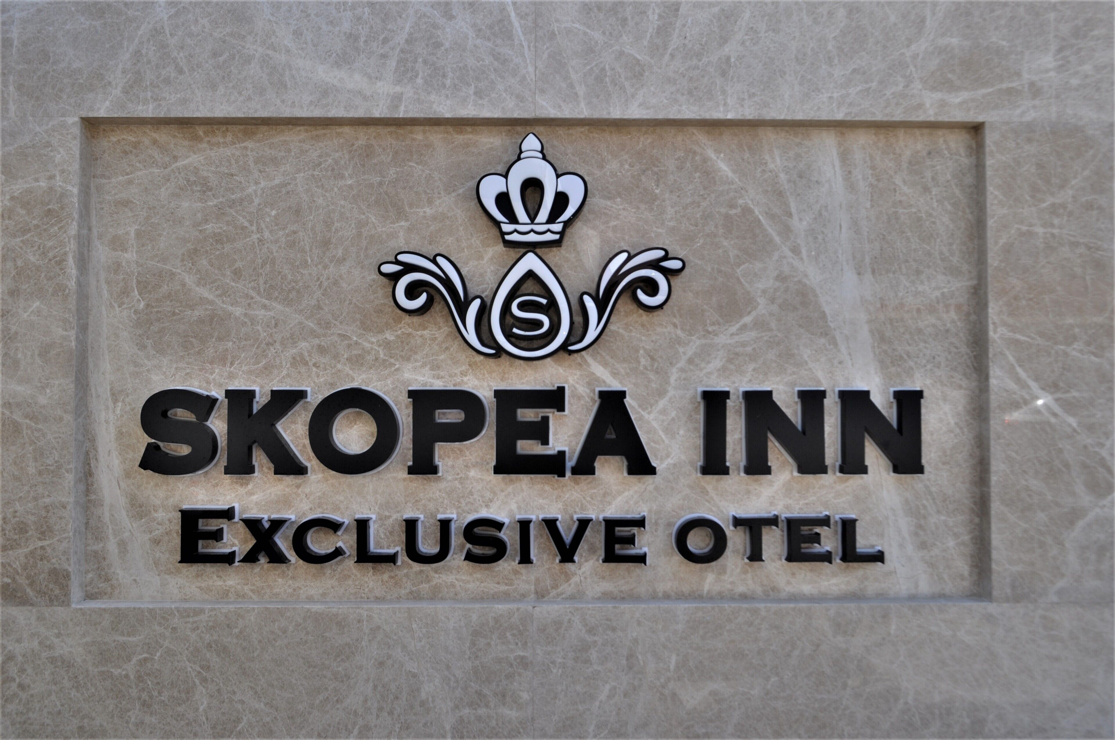 A sign for the Skopéa Inn, an exclusive hotel.