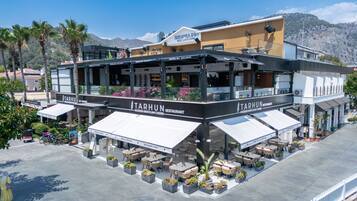 Un ristorante moderno con posti a sedere all'aperto, chiamato 'TARHUN', con una terrazza e vista sulla zona circostante.
