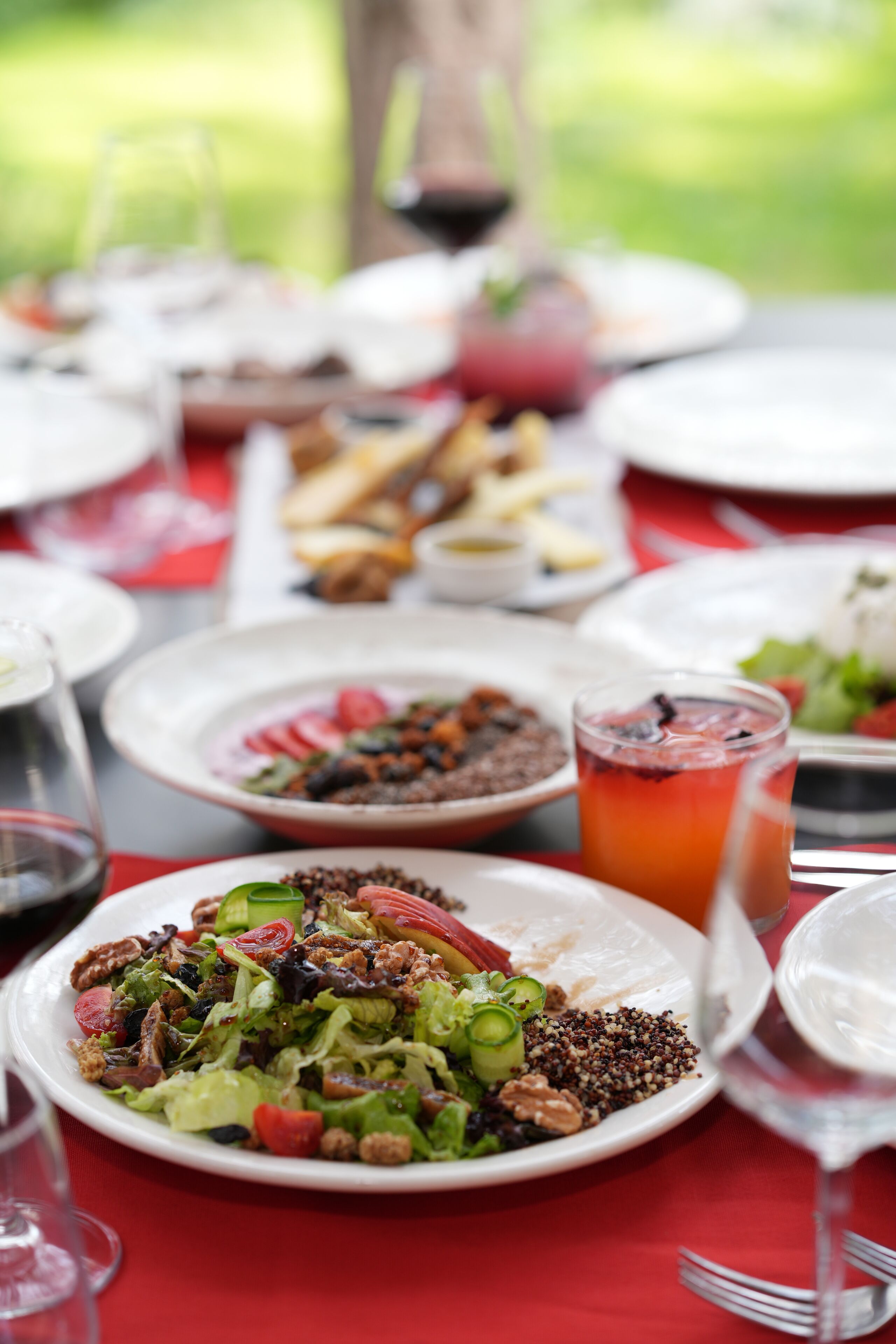 A table set with various dishes, glasses of beverages, and cutlery.