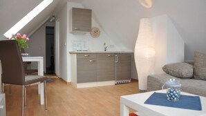 Un appartement moderne comprenant une cuisine, un coin repas et un salon.
