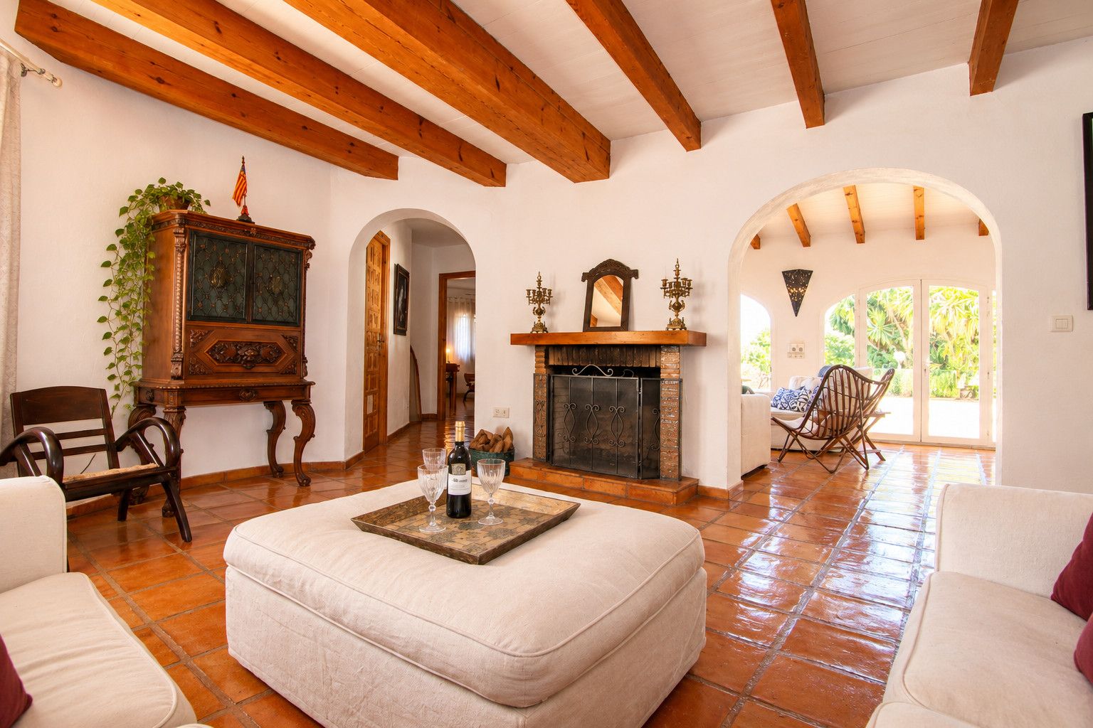 Una sala de estar amplia con chimenea, un aparador de madera y un comedor con sillas.