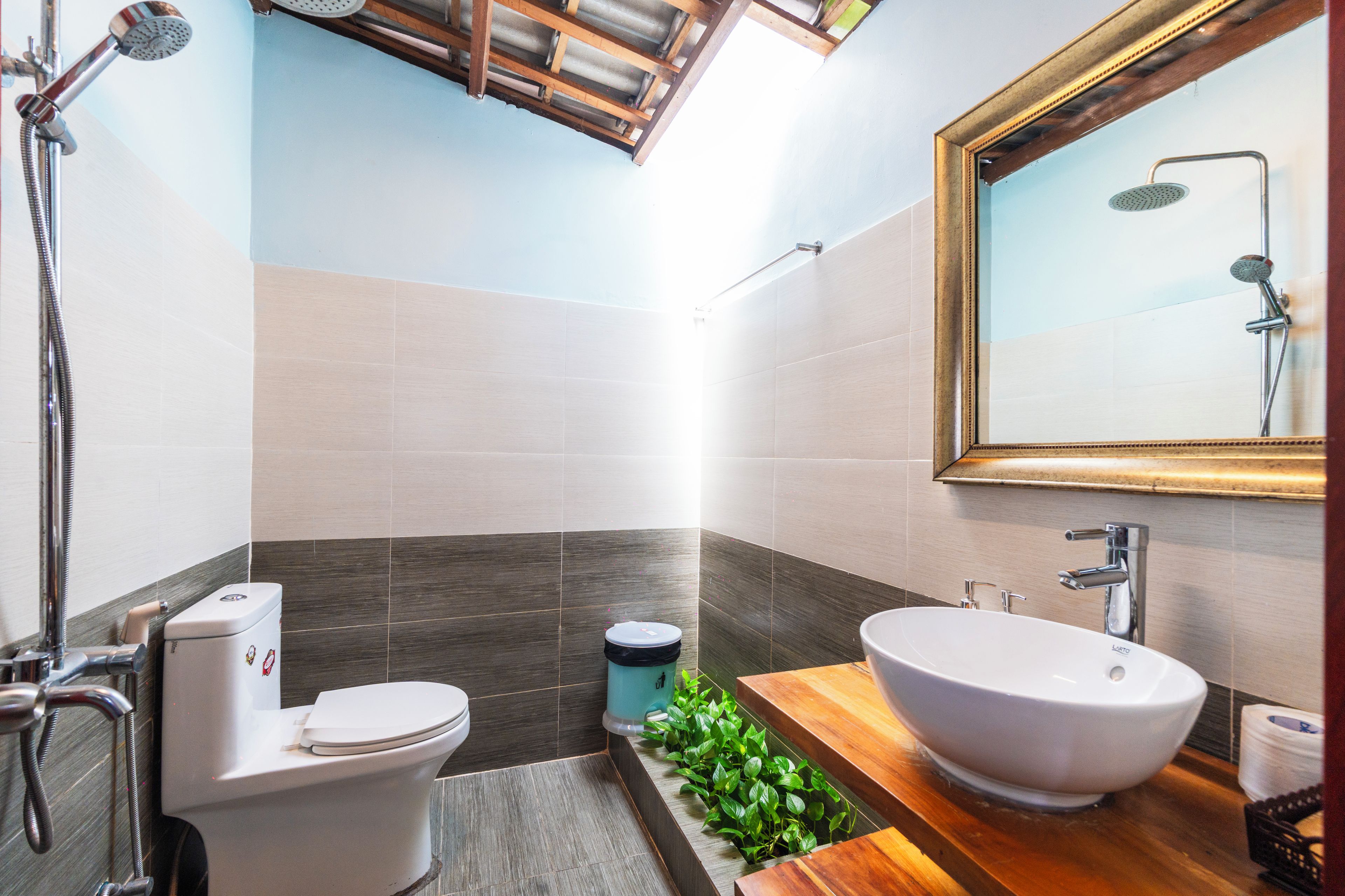 Un baño moderno con inodoro, bidé y un lavamanos grande con un espejo encima.