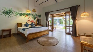 A bedroom with a wooden bed, a round woven rug, and a large window with curtains. - Green Bungalow Phu Quoc (Phu Quoc)