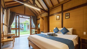 A wooden-framed room with a bed, a chair, and a view of the outdoors. - Green Bungalow Phu Quoc (Phu Quoc)