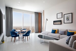 A modern living room with a sofa, chairs, a coffee table, and artwork on the wall.