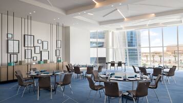 A conference room with a large table, chairs, and framed pictures on the wall.