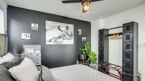 A bedroom with a bed, a dresser, a desk, a chair, a plant, and a wardrobe. - Historic Home < 2 Mi to Daytona Beach & Pier! (Daytona Beach)