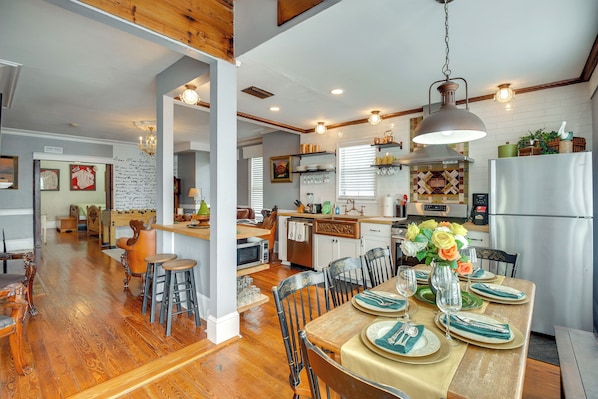 A spacious kitchen with a dining area, wooden floors, and a variety of kitchen appliances. - Historic Home < 2 Mi to Daytona Beach & Pier! (Daytona Beach)
