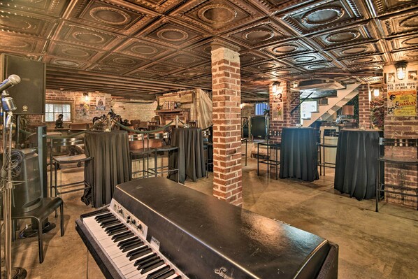 A spacious venue with a grand piano, brick columns, and a high, ornate ceiling. - Downtown Daytona Beach Unit: Walk to Halifax River (Daytona Beach)